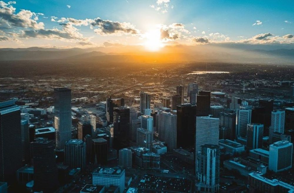 The sun sets behind the Denver skyline. (RNS/Unsplash/Nils Huenerfuerst)