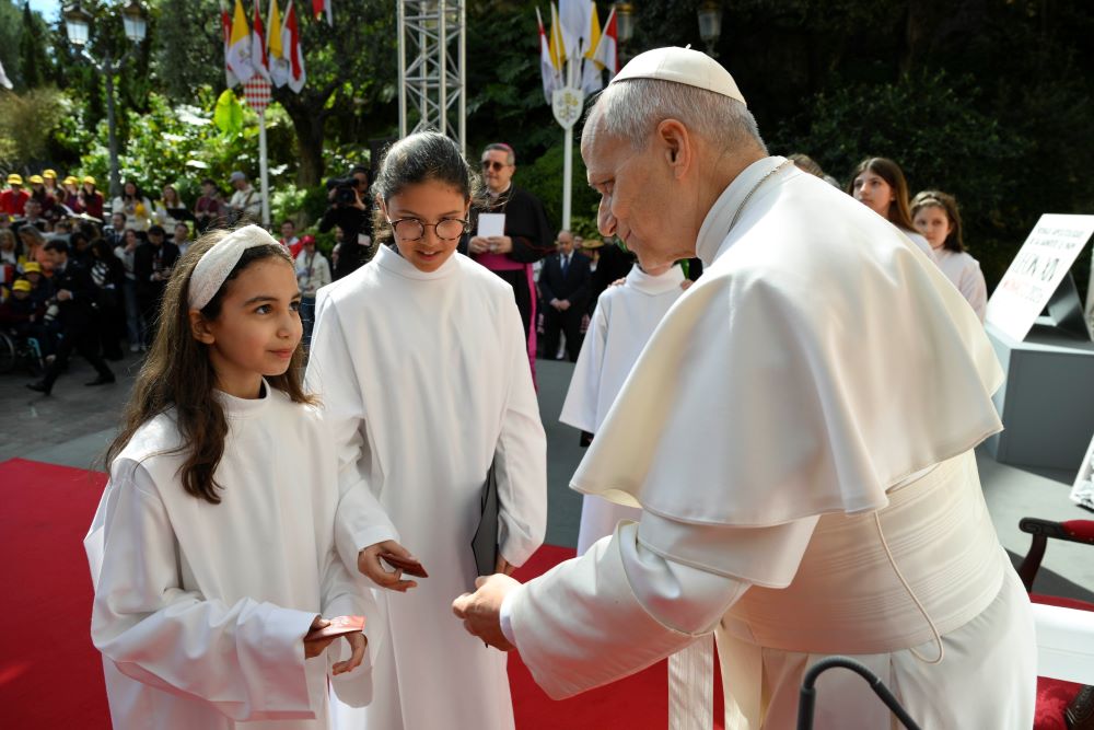 Pope Leo XIV presents young women with gifts as he leads a meeting with young people and catechumens outside the church of St. Devota, as part of a one-day apostolic trip in Monaco, March 28. (OSV News/Vatican Media/Simone Risoluti)