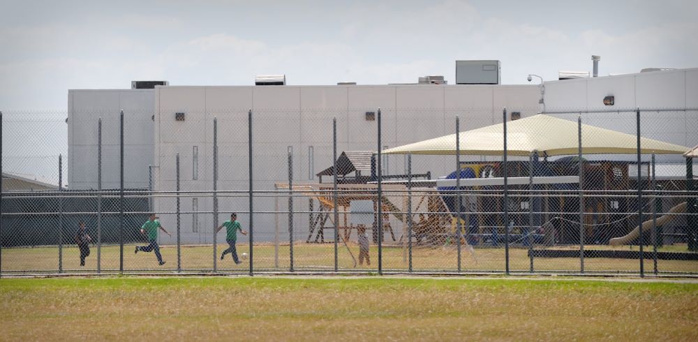 Children are pictured in a file photo playing in a double-fenced playground area outside the T. Don Hutto Family Residential Facility, an ICE detention center operated by CoreCivic, in Taylor, Texas. (OSV News/Bahram Mark Sobhani)
