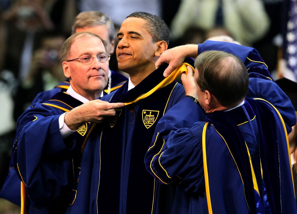The chairman of the University of Notre Dame's board of trustees, Richard Notebart, and university registrar Harold Pace present U.S. President Barack Obama with an academic stole signifying the honorary degree he received during the commencement ceremony at the university in Notre Dame, Ind., May 17, 2009. (CNS/Christopher Smith)