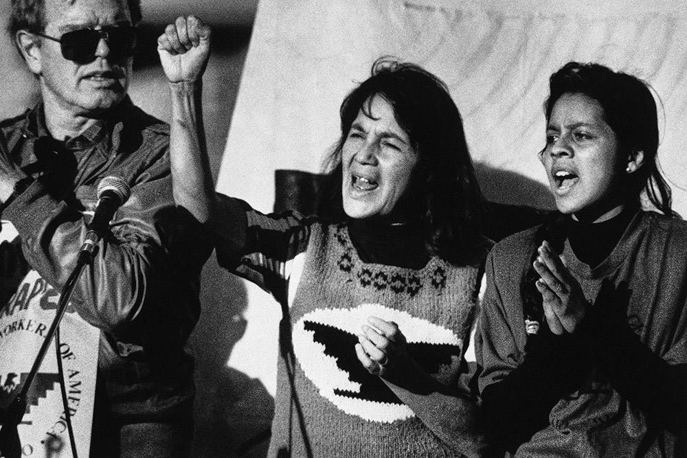 United Farm Workers leader Dolores Huerta, center, leads a rally in San Francisco's Mission District on Nov. 19, 1988, along with Howard Wallace, left, president of the San Francisco chapter of the UFW, and Maria Elena Chavez, right, the daughter of César Chavez. (AP/Court Mast, File)