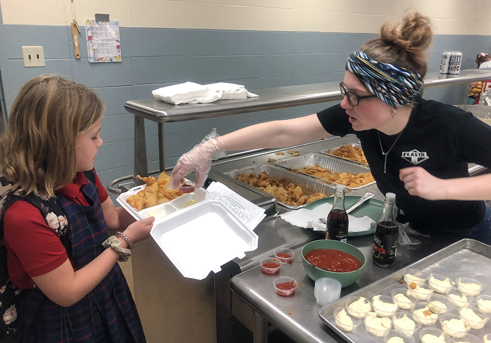 A student waits to be served during the Lenten fish fry at St. Margaret of Scotland Catholic Church in March 2023. (Courtesy of St. Margaret of Scotland Catholic Church)