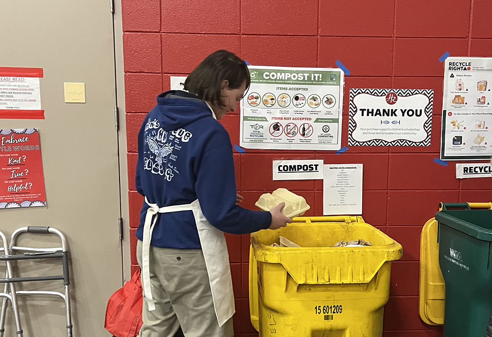 A parishioner at Holy Redeemer Catholic Church, in Webster Groves, Missouri, places a compostable food container into a compost bin during a Lenten fish fry. Holy Redeemer was one of 15 parishes in the St. Louis Archdiocese to receive a grant to help reduce waste at the Friday meatless meals. (Jamie Hasemeier)