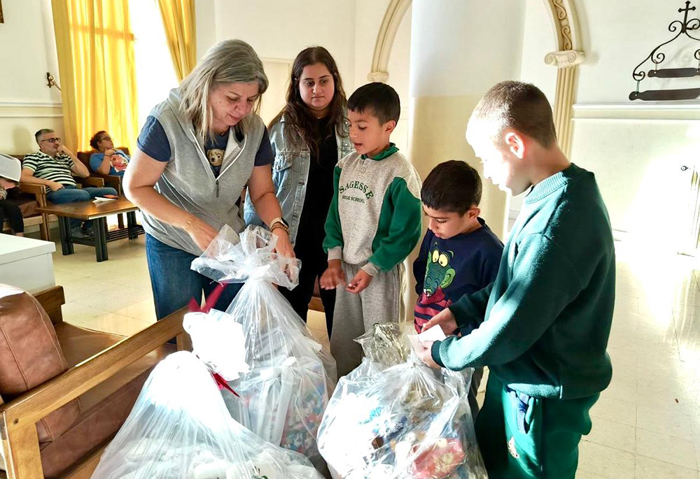 Rima Abi Karam, who runs the aid office for the Sisters of Jesus and Mary in Beirut, distributes toys and clothes to Lebanese children who fled from their towns in southern Lebanon because of war, in October 2024. (Courtesy of Rima Abi Karam)
