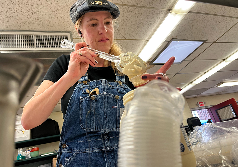 A parishioner at St. Margaret of Scotland Catholic Church, in St. Louis, scoops tartar sauce into individual plastic containers during the annual Lenten fish fry March 31, 2023. This year, with the help of a grant from the St. Louis Archdiocese's Laudato Si' Commission, the parish for the first time will compost leftover food and compostable materials in an effort to reduce waste. (Courtesy of St. Margaret of Scotland Catholic Church)