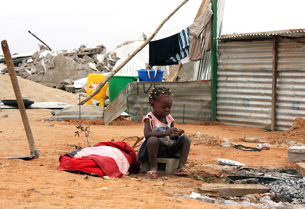 A girl is pictured in a file photo outside her home in Luanda, Angola. (CNS/Reuters/Henrique Almeida)