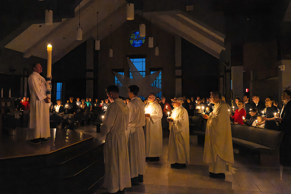 Deacon Jeff Prickette, pastoral leader at Prince of Peace Parish in Bellevue, Wis., holds the pascal candle in the church sanctuary during the Service of Light, part of the Easter Vigil liturgy held April 8, 2023. (OSV News/Sam Lucero)