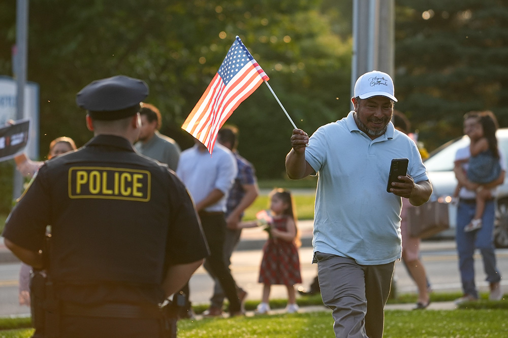 A man holds a U.S. flag as he attends a pro-immigrant march and rally following a Spanish-language Mass at St. John the Evangelist Church in Riverhead, N.Y., June 22, 2025, the feast of the Body and Blood of Christ. St. John's parish social ministry organized the event, which drew about 300 participants. (OSV News/Gregory A. Shemitz)