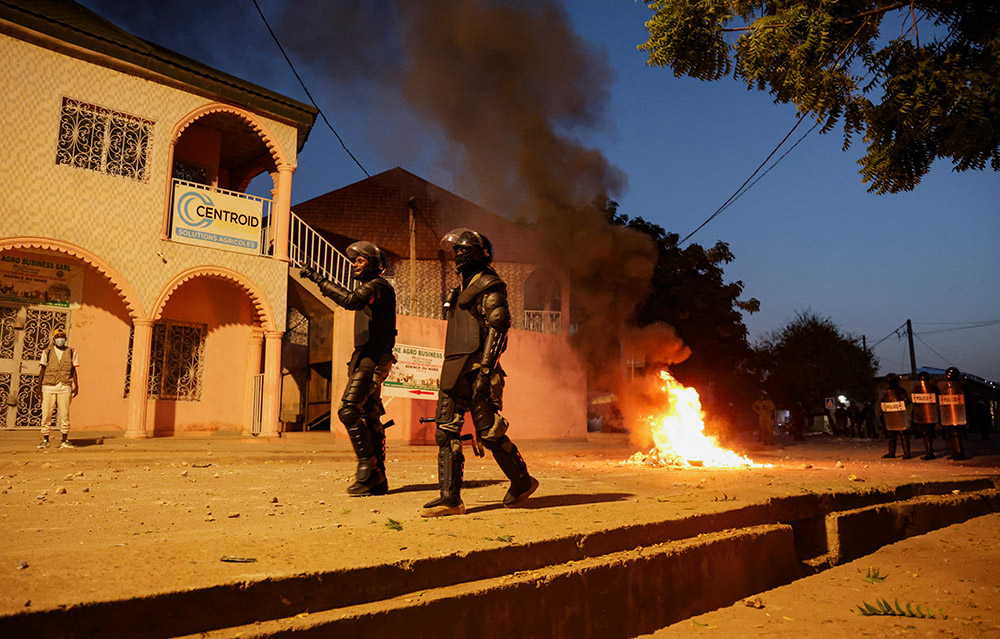 Riot police walk on a street as a fire burns during clashes with supporters of Cameroon opposition leader Issa Tchiroma Bakary in Garoua, Cameroon, Oct. 31, 2025. (OSV News/Reuters/Desire Danga Essigue)