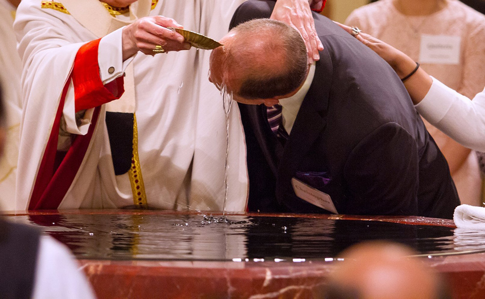 A file photo shows a catechumen being baptized during the Easter Vigil. (OSV News/Texas Catholic Herald/James Ramos)