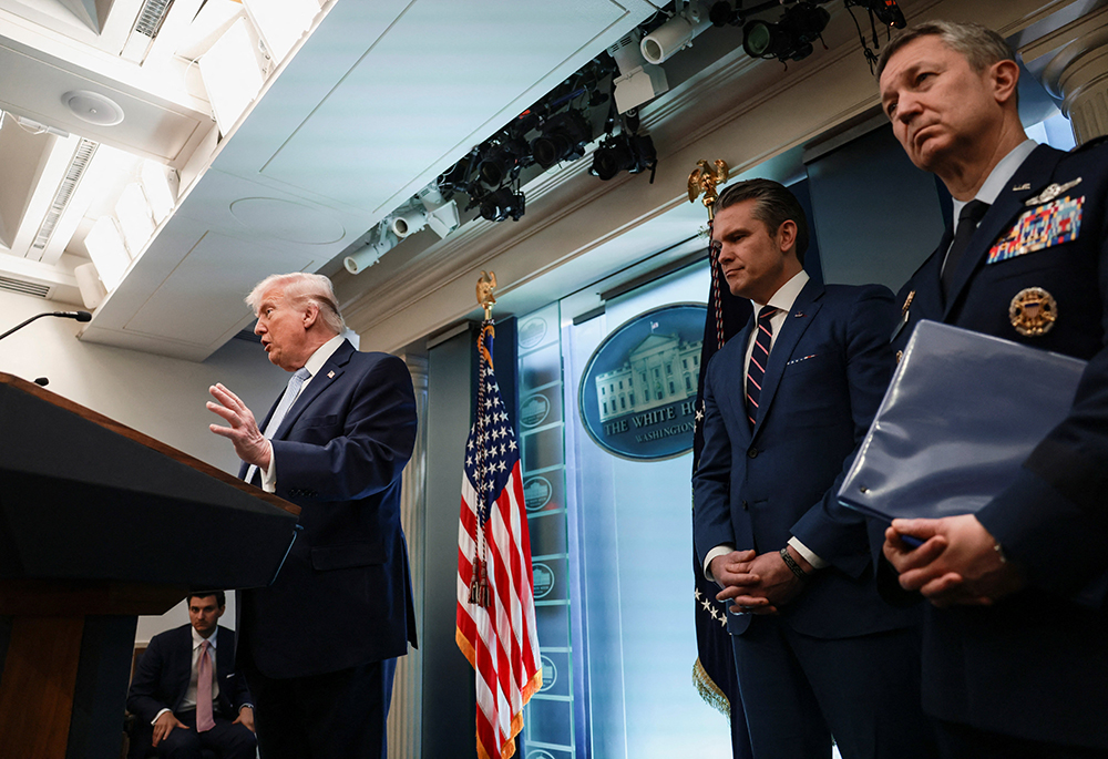 U.S. Secretary of Defense Pete Hegseth and Chairman of the Joint Chiefs of Staff Gen. Dan Caine listen while President Donald Trump answers questions from the media during a news conference in the James S. Brady Press Briefing Room at the White House in Washington April 6, 2026. (OSV News/Reuters/Evelyn Hockstein)