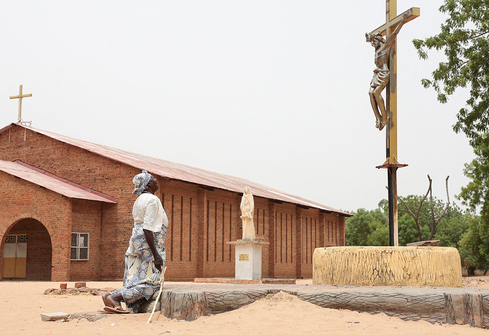 A Catholic worshipper kneels before a crucifix on Easter April 5, 2026, outside the Cathedral of St. Anne in Yagoua, Cameroon. (OSV News/Reuters/Desire Danga)