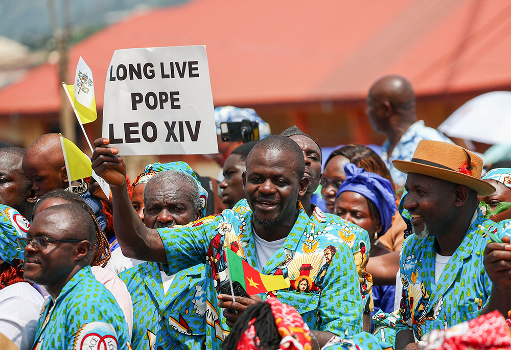A man holds a sign as people gather outside St. Joseph's Cathedral in Bamenda, Cameroon, April 16, 2026, as they wait for the arrival of Pope Leo XIV for a Meeting for Peace. (OSV News/Reuters/Guglielmo Mangiapane)