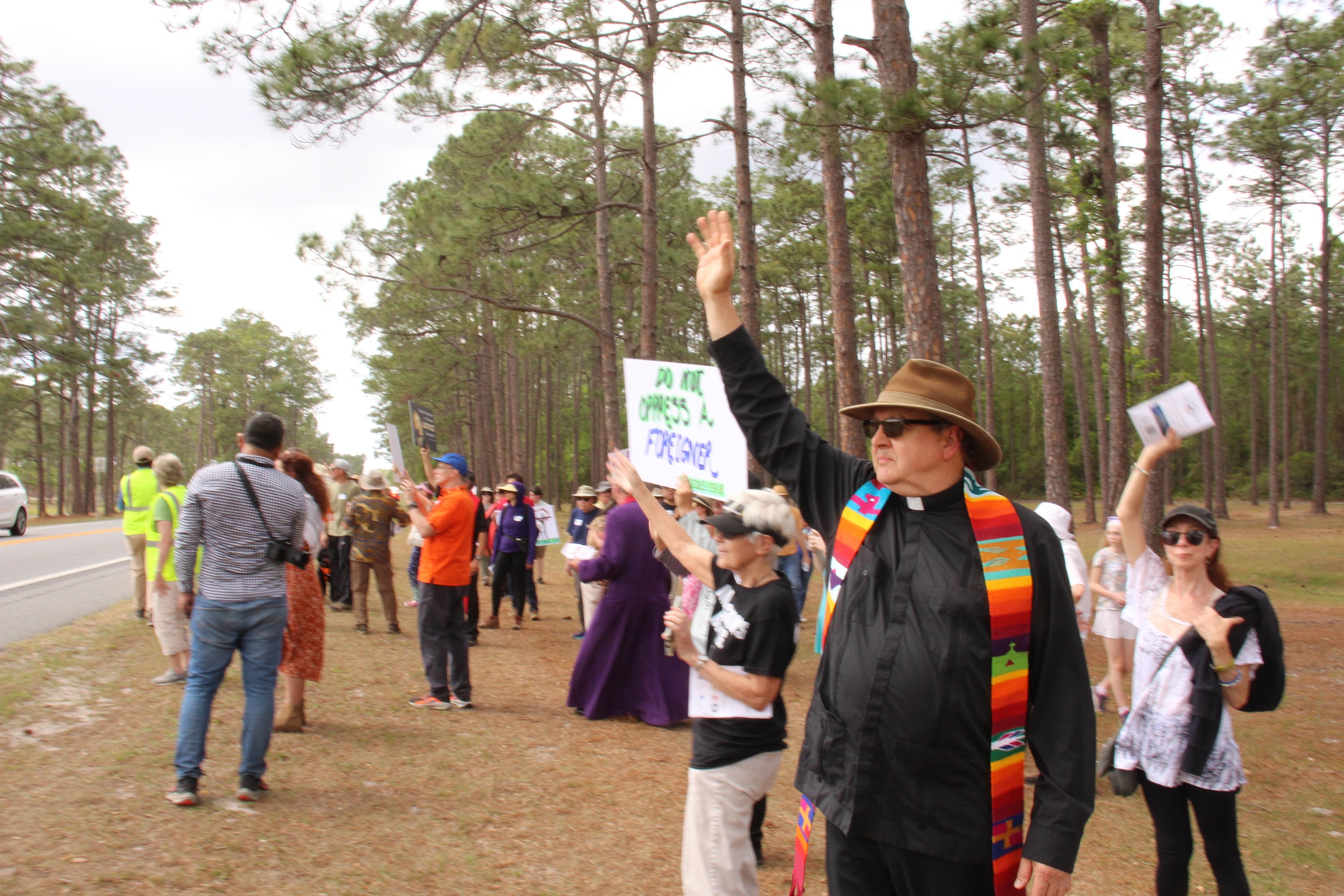Immigrant advocates, including the Rev. Russell l. Meyer, executive director of the Florida Council of Churches, center front, wave on Good Friday, April 3, 2026, to detainees housed at Deportation Depot in Sanderson, Fla., which formerly served as Baker Correctional Institution. 