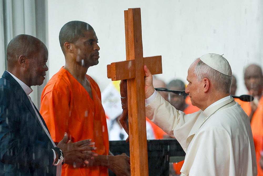 Pope Leo XIV receives a cross from an inmate during the pontiff's visit to Bata prison in Equatorial Guinea, April 22, 2026. (OSV News/Reuters/Guglielmo Mangiapane)