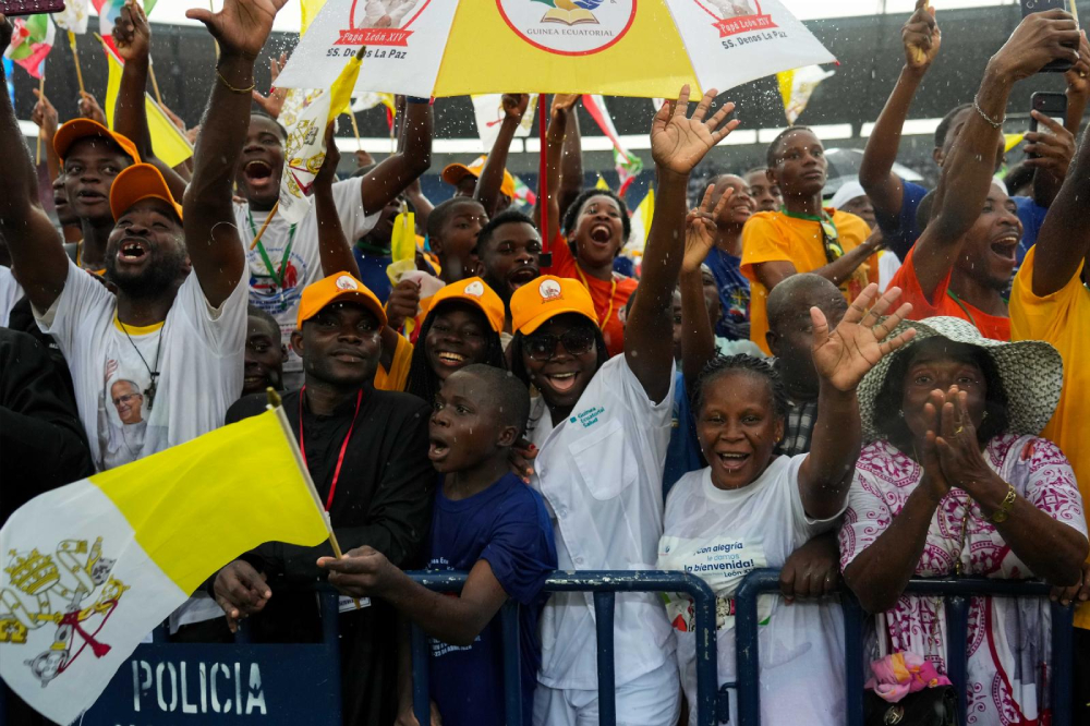 Young people celebrate in the rain as they wait to have a meeting with Pope Leo XIV at Bata Stadium in Bata, Equatorial Guinea, April 22, 2026. (CNS/Lola Gomez)