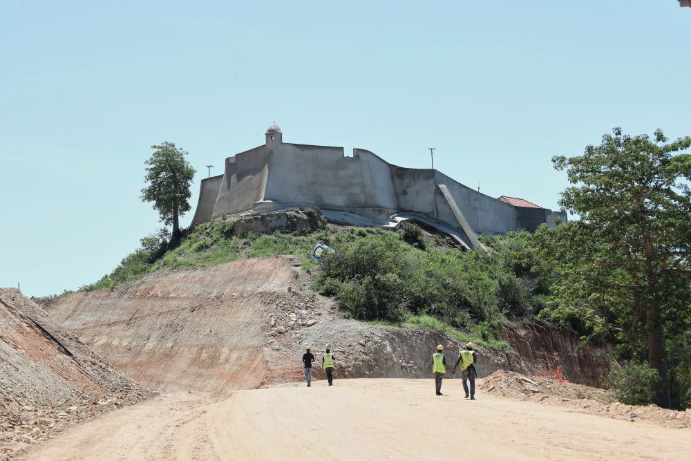 Workers walk by the 16th-century fortress in Muxima, Angola, Saturday, April 11, 2026. The church was part of a fortress complex that became a central hub in the Portuguese slave trade. (AP)