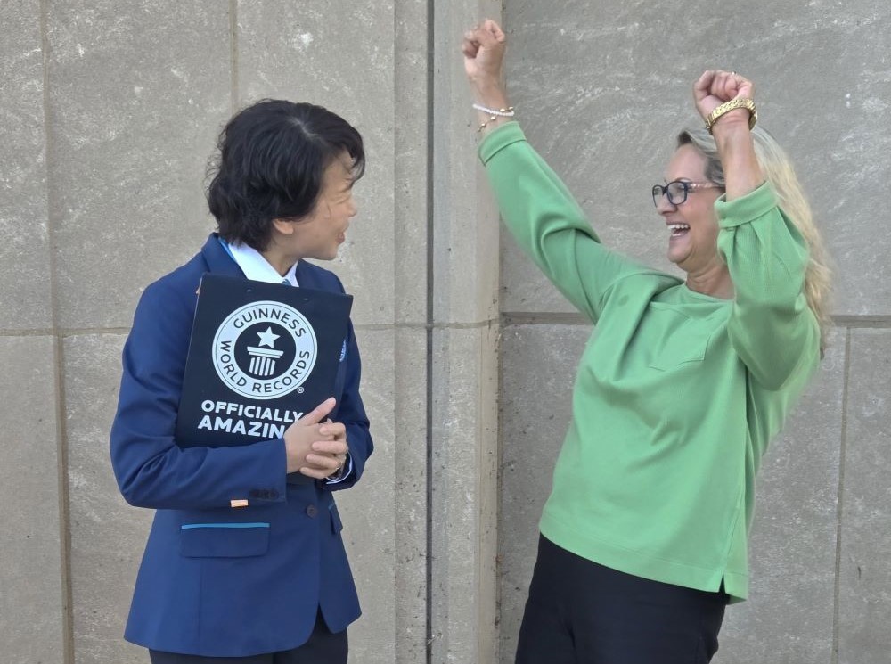 Rev. Vicki Garlock receives her Guinness World Record certificate outside Madonna Della Strada Chapel at Loyola University Chicago, on the shore of Lake Michigan in September 2025. (Courtesy of Vicki Garlock)