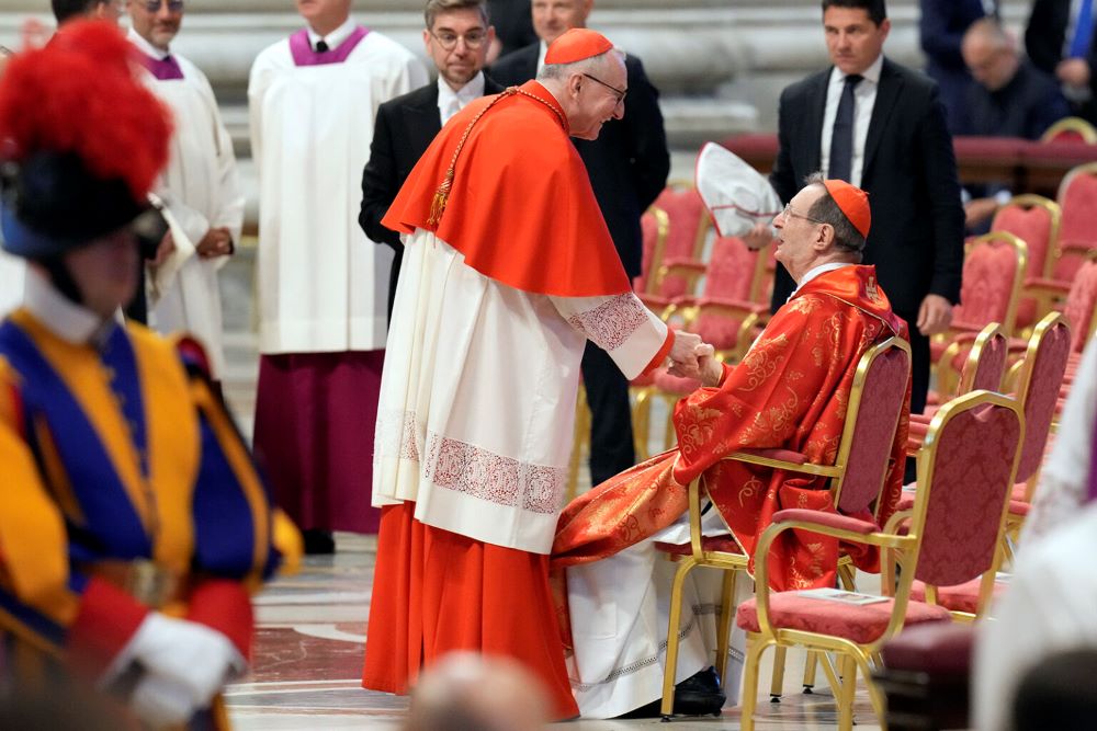 Cardinal Pietro Parolin, center, greets Cardinal Giovanni Lajolo during a final Mass celebrated by cardinals inside St. Peter's Basilica, before the conclave to elect a new pope at the Vatican May 7, 2025. (RNS/AP/Gregorio Borgia)