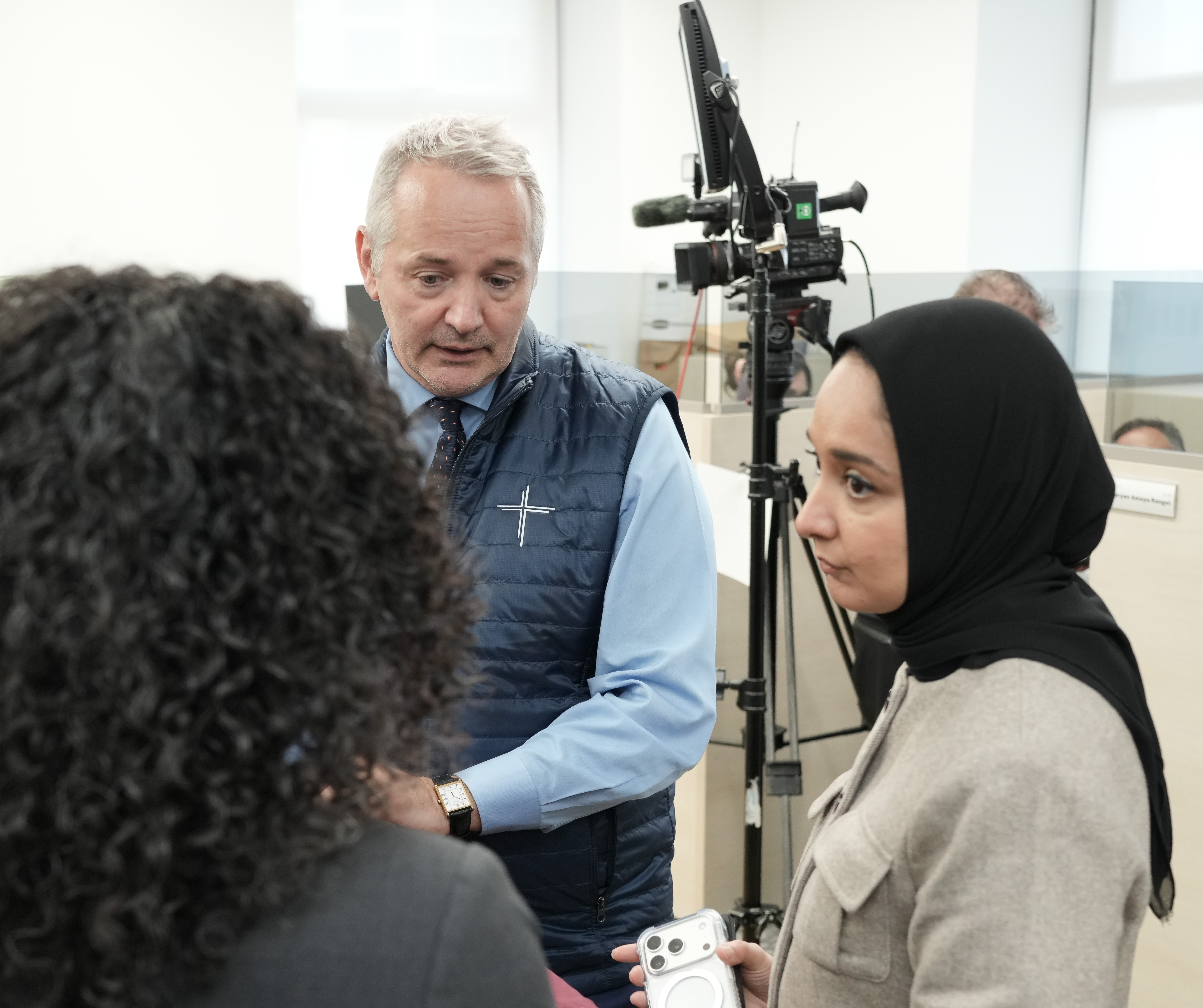 J. Antonio Fernández, CEO of Catholic Charities of the Archdiocese New York, and Faiza Ali, commissioner at the New York City Mayor's Office of Immigrant Affairs York, visit booths where volunteers held an immigration information phone bank to offer guidance and respond to local immigrants' concerns April 21. (Courtesy of Catholic Charities of the Archdiocese of New York)