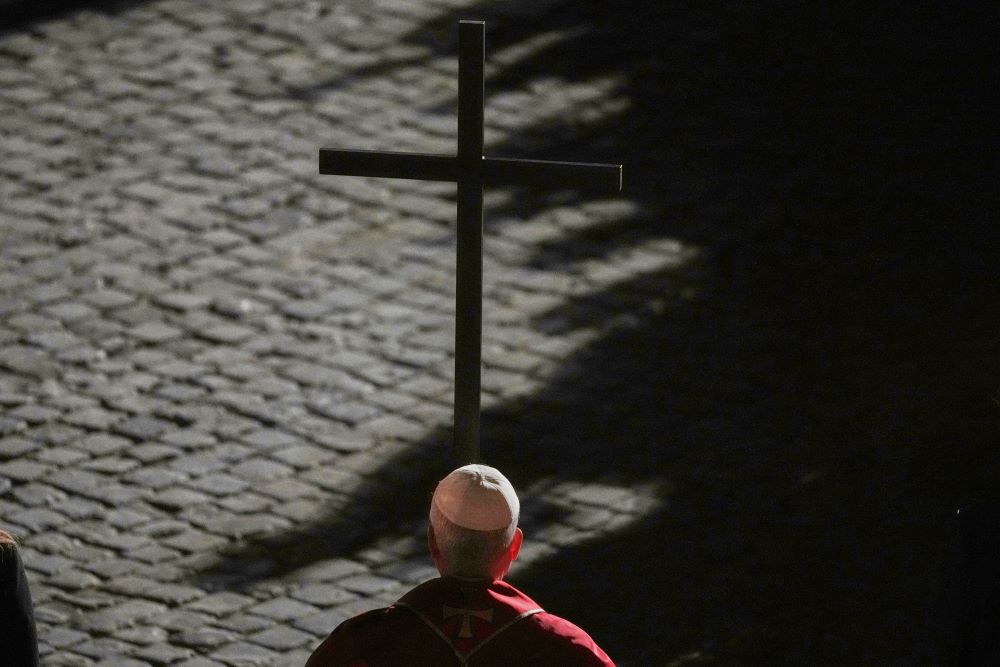 Pope Leo XIV carries a lightweight, 5-foot wooden cross during the Via Crucis, the torchlit Good Friday Stations of the Cross procession at the Colosseum in Rome April 3. The Stations of the Cross symbolically retrace Jesus Christ's steps to his crucifixion on Calvary in Jerusalem. (AP/Alessandra Tarantino)