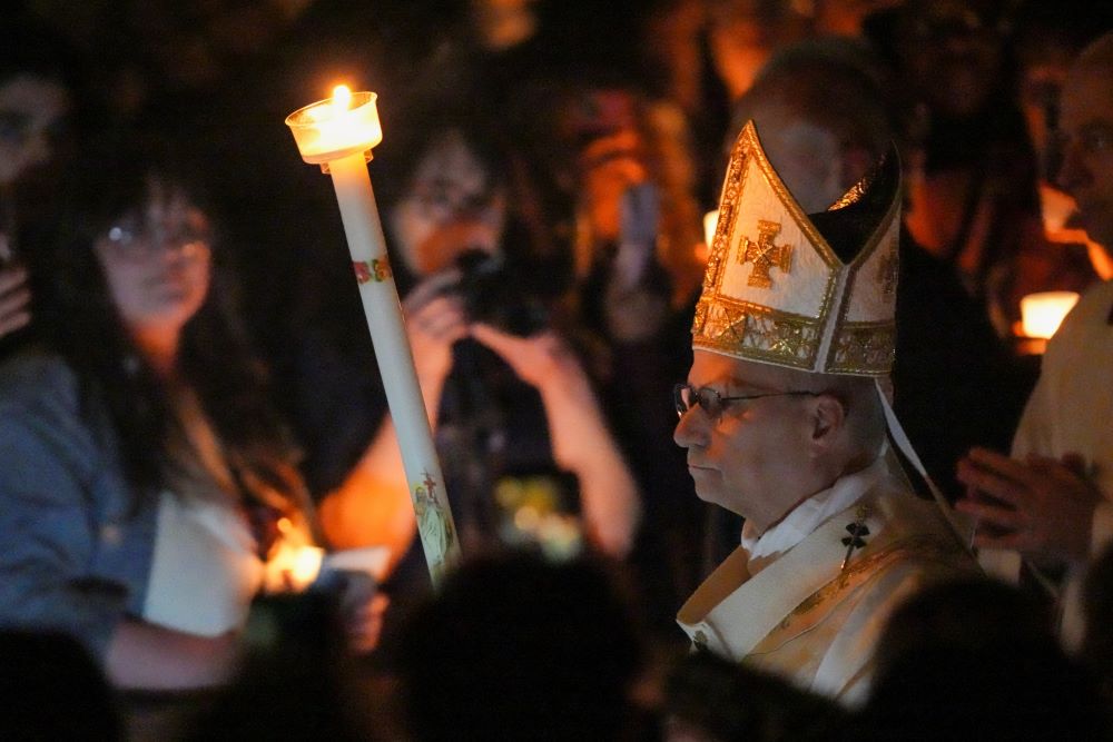 Pope Leo XIV carries a candle as he arrives to celebrate the Easter Vigil in St. Peter's Basilica at the Vatican April 4. (CNS/Lola Gomez)
