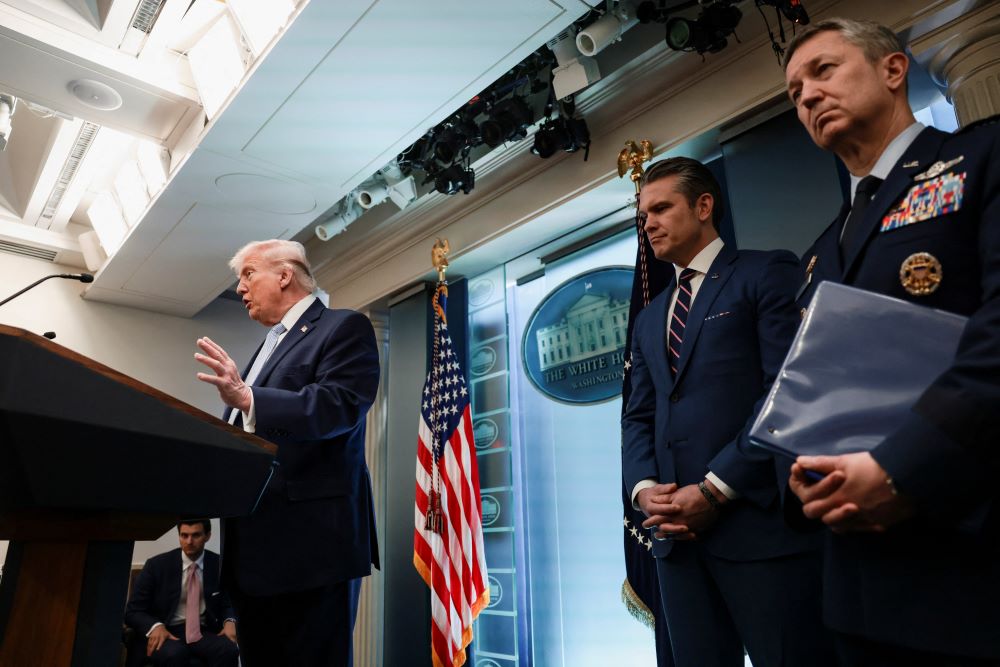 U.S. President Donald Trump answers questions from the media during a news conference about Iran April 6. Secretary of Defense Pete Hegseth and Chairman of the Joint Chiefs of Staff Gen. Dan Caine listen as he speaks. (OSV News/Reuters/Evelyn Hockstein)