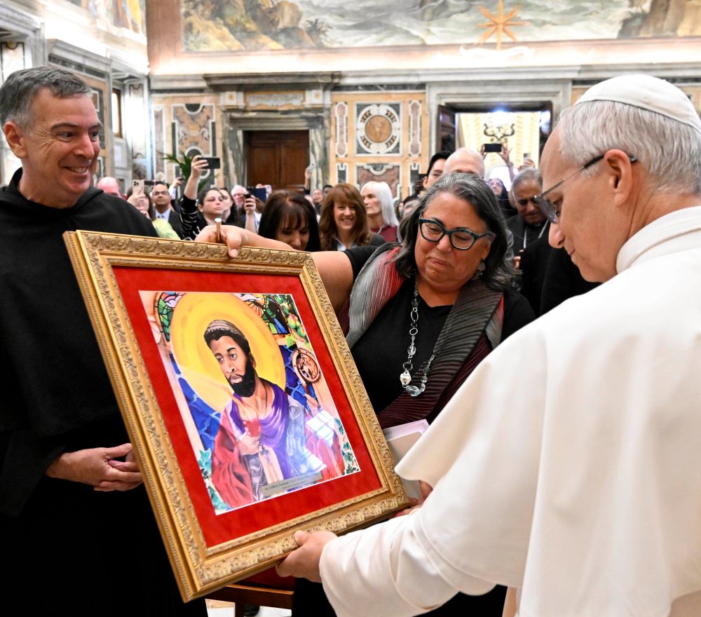 Pope Leo XIV receives a copy of a painting of St. Augustine called "An Unlikely Aquilegia: North African Saint of Hippo" from Michele Pistone, founder and faculty director of the Mother Cabrini Institute on Immigration at Villanova University, during an audience at the Vatican Oct. 2, 2025. Fr. Joseph Farrell, prior general of the Augustinians, looks on. (CNS/Vatican Media)