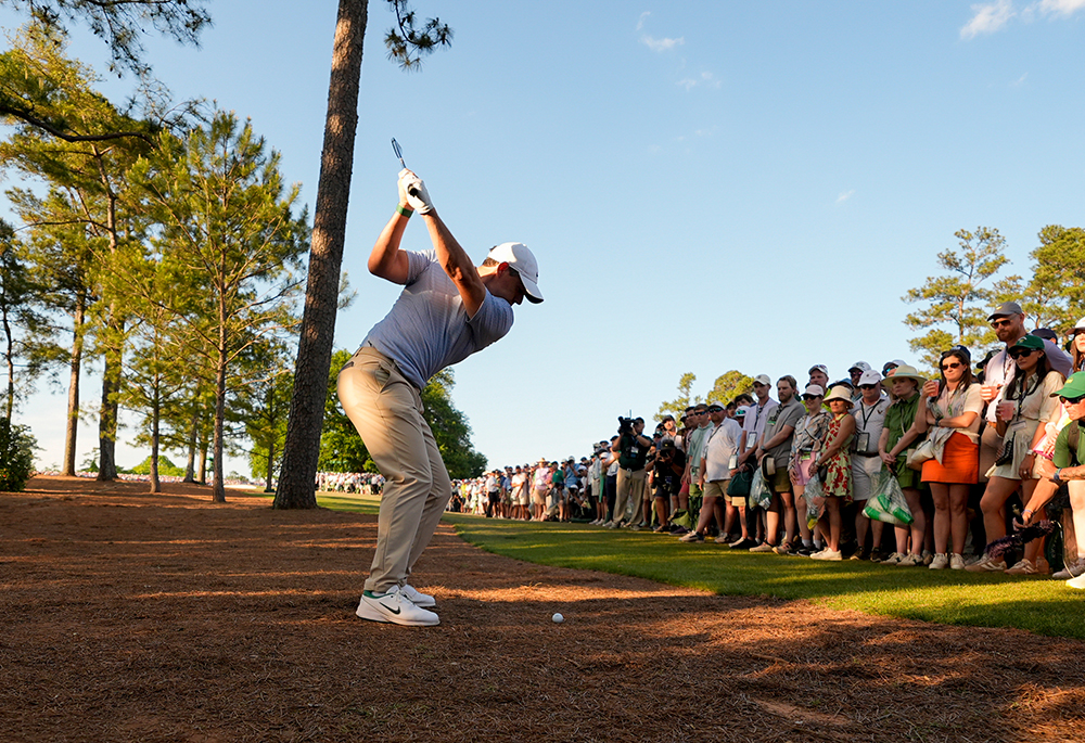 Rory McIlroy, of Northern Ireland, hits from the pine straw on the 18th hole during the final round of the Masters golf tournament at the Augusta National Golf Club, Sunday, April 12, 2026, in Augusta, Georgia. (AP photo/Gerald Herbert)