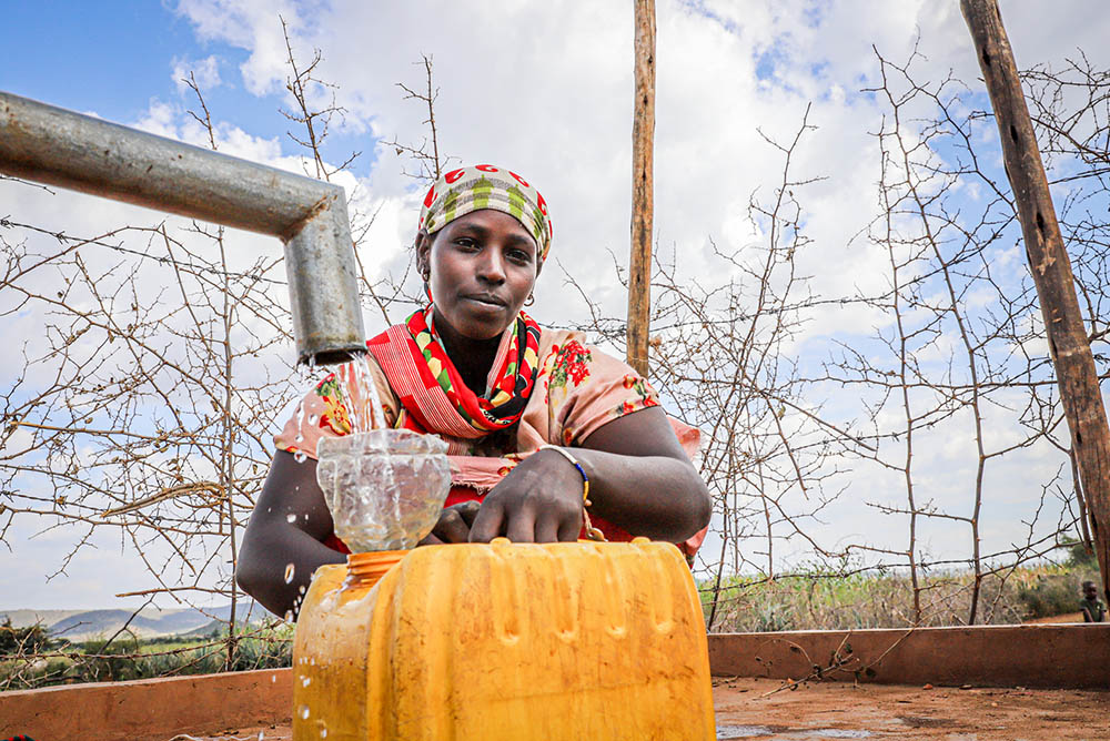 A woman fills a container from a water pump in Oromia, Ethiopia. Catholic Relief Services has worked in the community with local partners and government officials to provide drought-tolerant seeds to small-scale farmers and help them take other measures to make crops more resilient. (Catholic Relief Services/Melikte Tadesse)