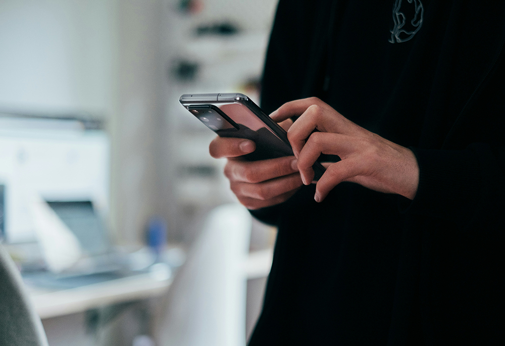 A man uses a smartphone in this photo illustration. (Unsplash/Jonas Leupe)