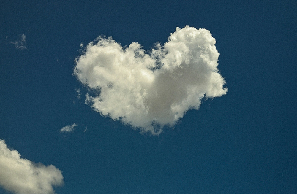 Cloud in the shape of a heart against a blue sky (Unsplash/Remi Clinton)