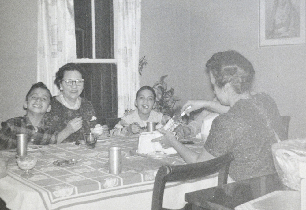 In this undated photo, Pope Leo XIV (then Robert Prevost, left) smiles while his mother (back to the camera) cuts a birthday cake in what his brother (right) guessed was the pope's ninth birthday, at the family home in the Chicago suburb of Dolton. (OSV News/Prevost family)