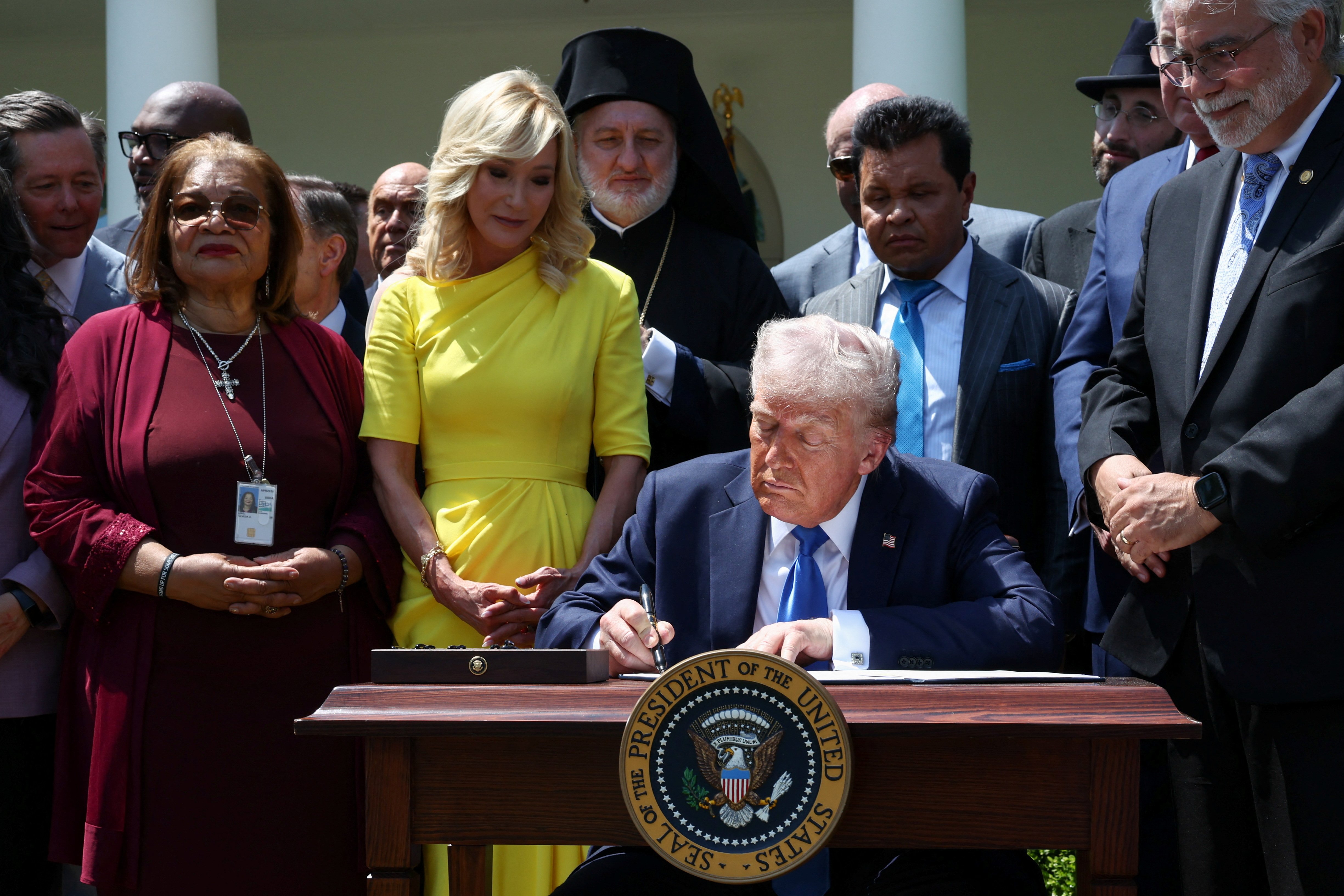 Paula White-Cain, senior adviser to the White House Faith Office, stands with faith leaders as U.S. President Donald Trump signs an executive order on the "Establishment of the Religious Liberty Commission" at the White House in Washington May 1, 2025. White-Cain will speak at the May 17 prayer rally "Rededicate 250." (OSV News/Reuters/Evelyn Hockstein)