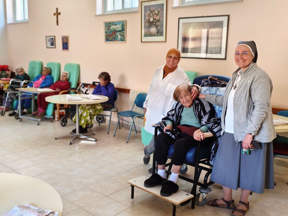 Home Notre Dame des Douleurs caretaker Amreh Kourd and home assistant manager Sr. Claire-Emmanuel Pontroué share a moment with a resident of the home in the communal dining room where the residents spent most of their daytime doing activities during the war. (Judith Sudilovsky)