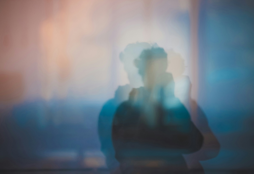 A photo illustration shows a blurry image of a person in silhouette, distorted with duplicate overlapping images of that same person, against a background that contains warm colors above and cooler colors below. (Unsplash/Xiangkun ZHU)(Unsplash/Xiangkun ZHU)