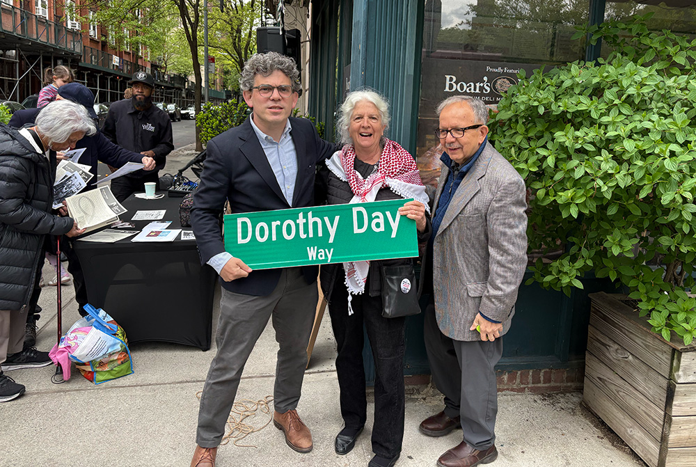 Martha Hennessy, Dorothy Day's granddaughter, Councilman Lincoln Restler (left) and Alex Avitabile, one of the primary organizers behind the street renaming who also knew Dorothy Day personally (right), holding the Dorothy Day Way sign after the unveiling in Brooklyn Heights on May 2. (NCR photo/Camillo Barone)