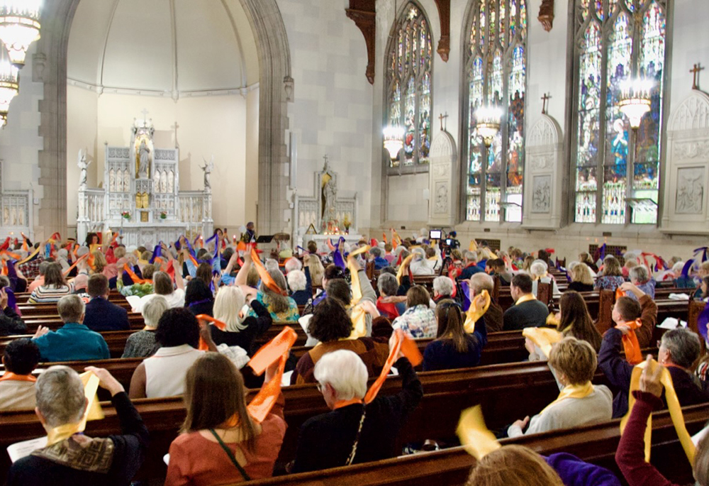 Attendees at the Women's Ordination Conference's 50th anniversary celebration wave multi-colored stoles Friday, May 22, 2026, in Detroit. (NCR photo/Dan Stockman)