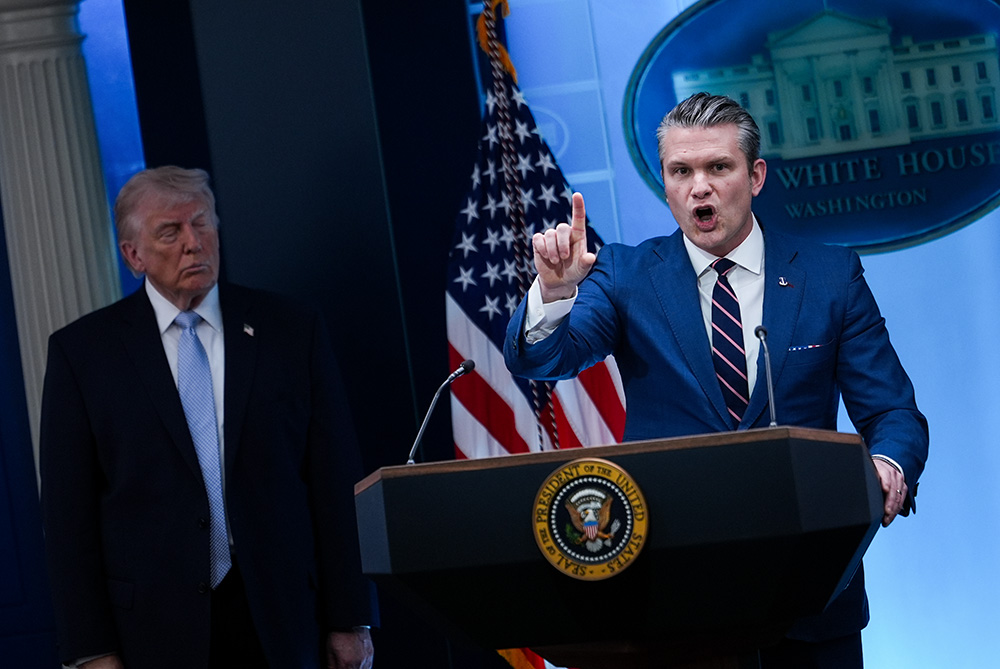President Donald Trump watches as Defense Secretary Pete Hegseth speaks with reporters in the James Brady Press Briefing Room at the White House April 6, 2026, in Washington. (AP/Julia Demaree Nikhinson)