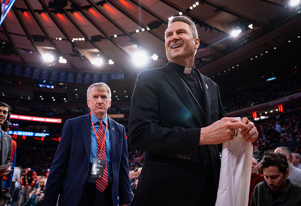 New York Archbishop Ronald Hicks smiles after receiving a "Hicks" St. John's jersey during a timeout at an NCAA college basketball game against Xavier, Feb. 9, 2026, in New York. (AP photo/Angelina Katsanis)