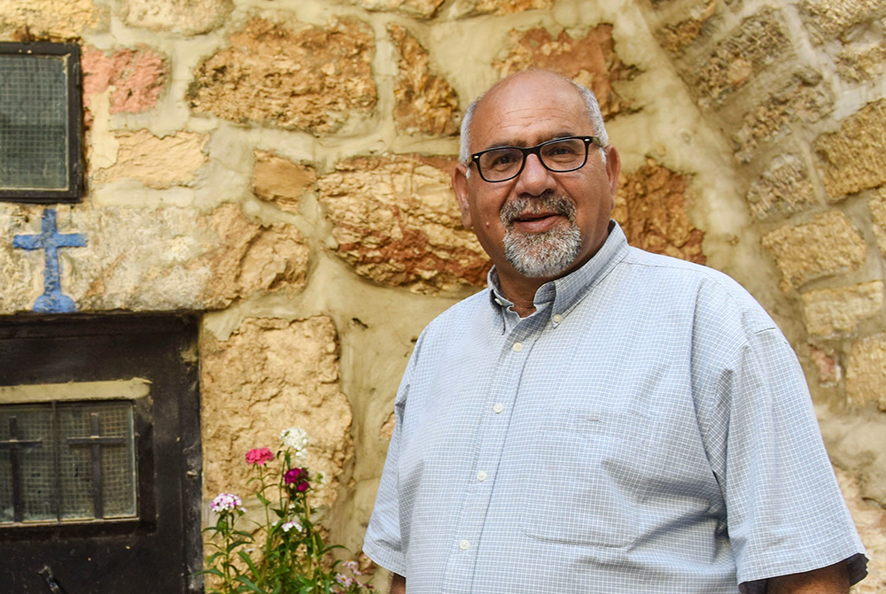 Zoughbi Zoughbi poses for a photo May 4, 2019, near the door of a cave that was the ancestral home of his family in Bethlehem, West Bank. (CNS/Debbie Hill)