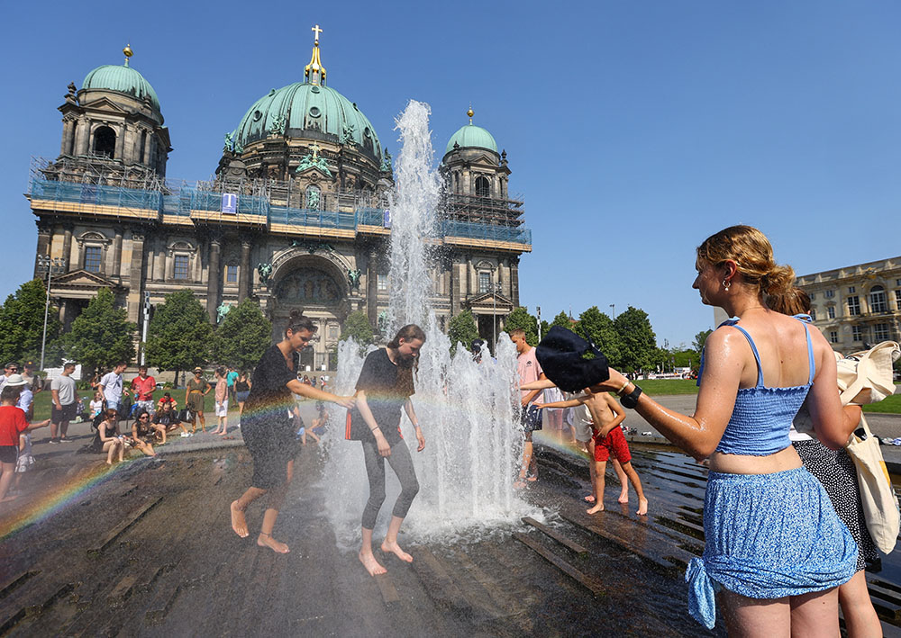 People cool off in a fountain in front of the Berlin cathedral during a heat wave July 19, 2022. (CNS/Reuters/Fabrizio Bensch)
