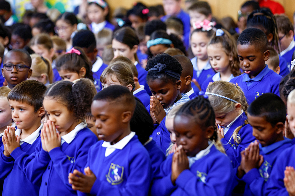 Students of St. Mary Magdalene Catholic Primary School in Milton Keynes, England, take part in a minute's silence Sept. 9, 2022, for Britain's Queen Elizabeth II, who died the previous day. (CNS/Reuters/Andrew Boyers)