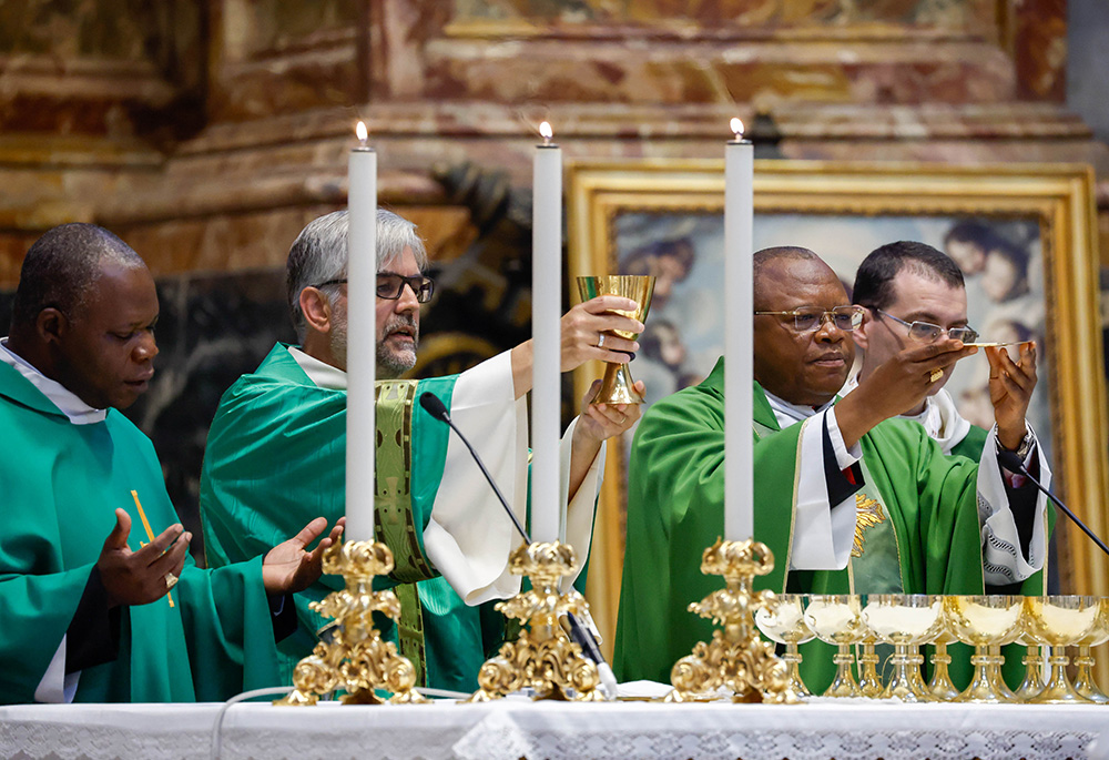 Congolese Cardinal Fridolin Ambongo of Kinshasa, right, elevates the host alongside concelebrants during Mass at the Altar of the Chair in St. Peter's Basilica at the Vatican Oct. 13, 2023, as part of the assembly of the Synod of Bishops. (CNS/Lola Gomez)