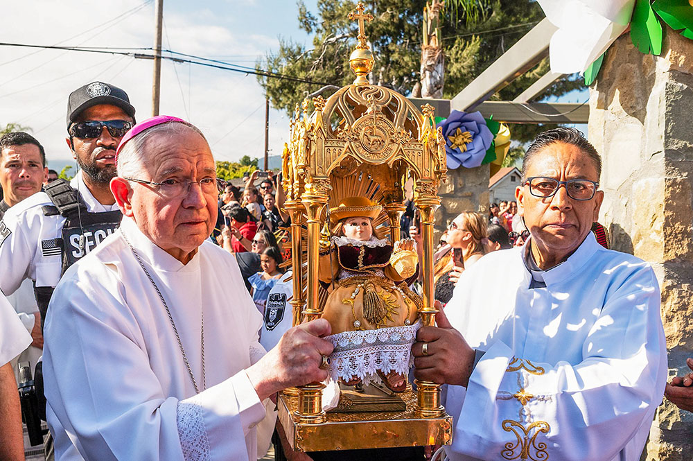 Los Angeles Archbishop José Gomez and Fr. José de Jesús López Acosta of Zacatecas, Mexico, carry a pilgrim image of Santo Niño de Atocha in procession before Mass at Our Lady of Guadalupe Church in Santa Paula, California, on May 25, 2024. (OSV News/Angelus/Víctor Alemán)