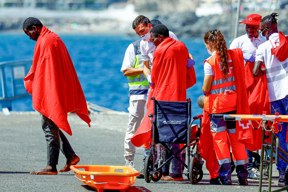 Migrants are treated by Red Cross volunteers after disembarking from a Spanish coast guard vessel at the port of Arguineguin, on the island of Gran Canaria, Spain, Aug. 28, 2024. (OSV News/Reuters/Borja Suarez)