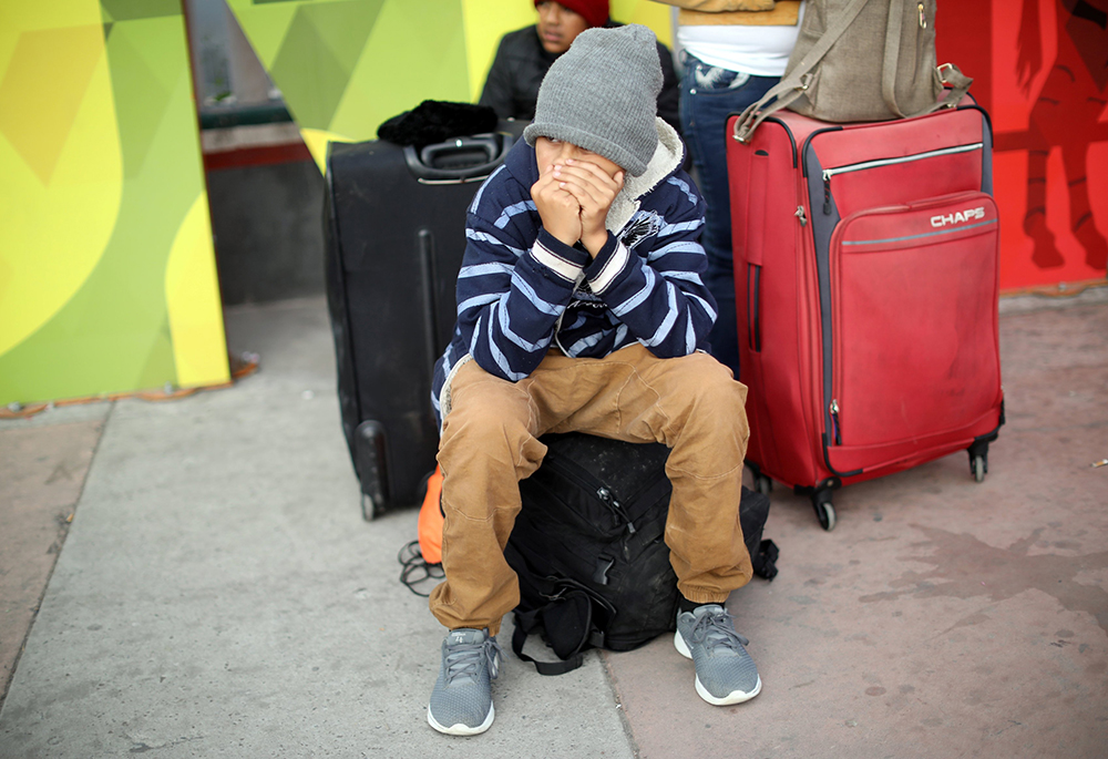 A young asylum-seeker sits on his backpack in Tijuana, Mexico, April 25, 2019, before crossing to the U.S. (OSV News/Reuters/Andres Martinez Casares)