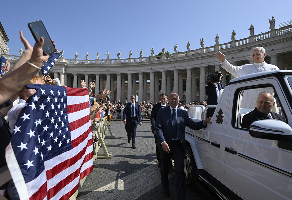 Pope Leo XIV waves to pilgrims holding a flag of the United States as he arrives in St. Peter's Square on the popemobile for his general audience at the Vatican June 18, 2025. (CNS/Vatican Media)