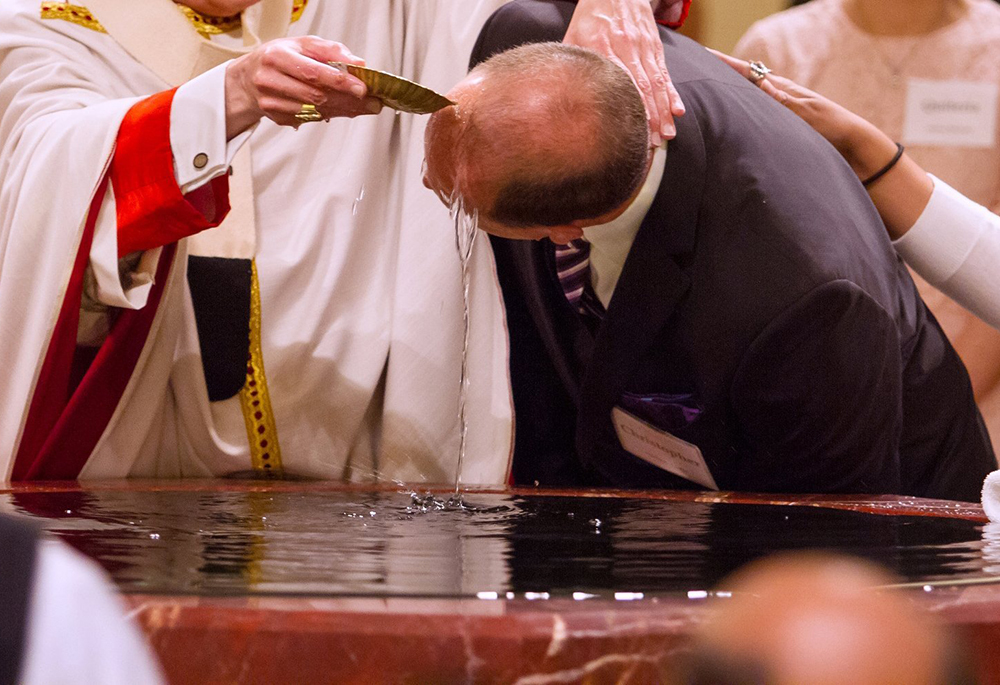 A file photo shows a catechumen being baptized during the Easter Vigil. (OSV News/Texas Catholic Herald/James Ramos)