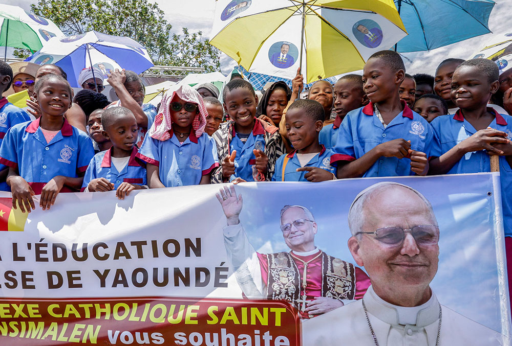Catholic school students hold a banner as the faithful gather at Yaoundé Nsimalen International Airport in Yaoundé, Cameroon, April 15, 2026, before Pope Leo XIV's arrival to begin his apostolic journey to the African country. (OSV News/Reuters/Luc Gnago)